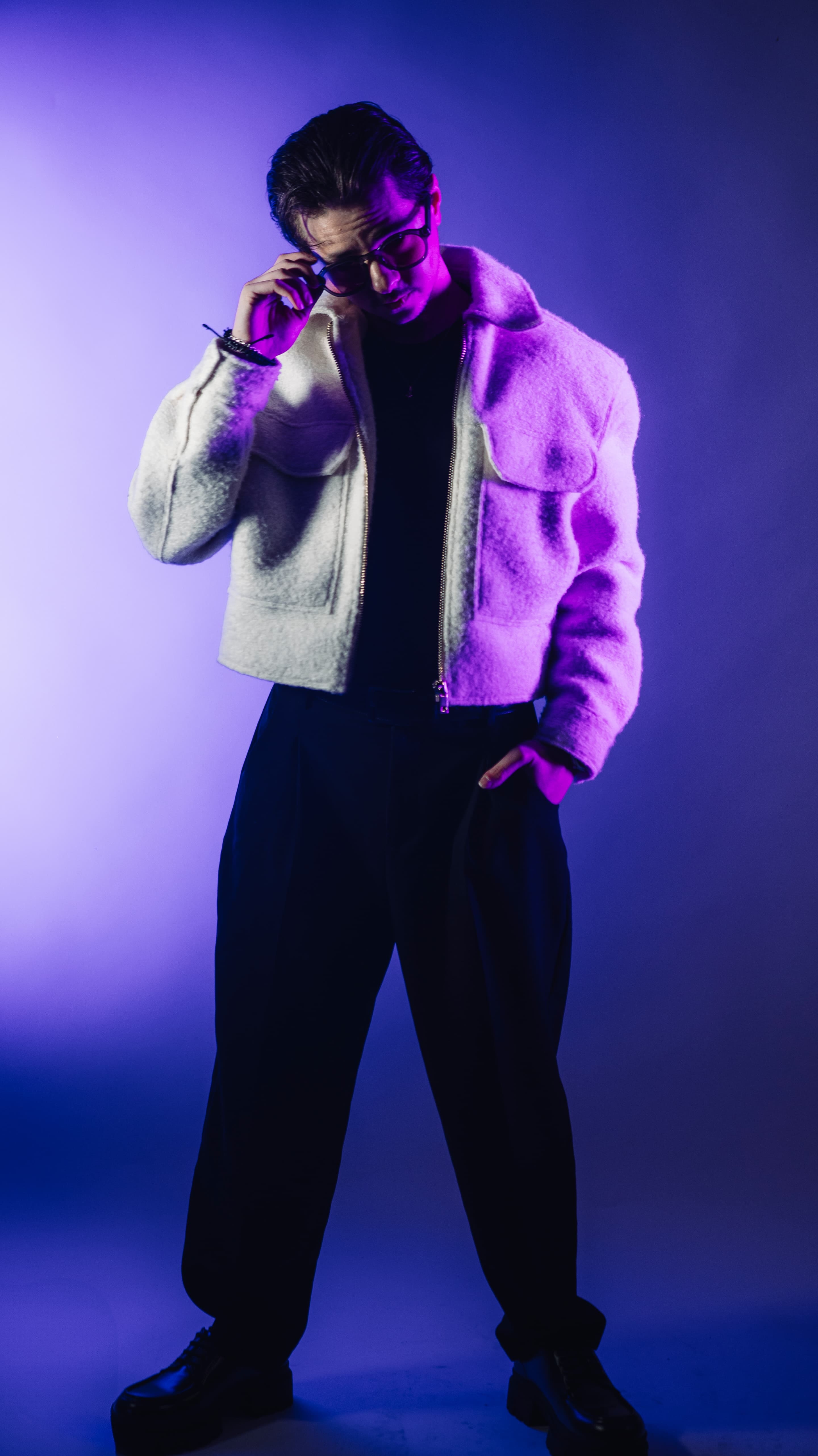 LEGALY ajustant ses lunettes sous un éclairage violet.